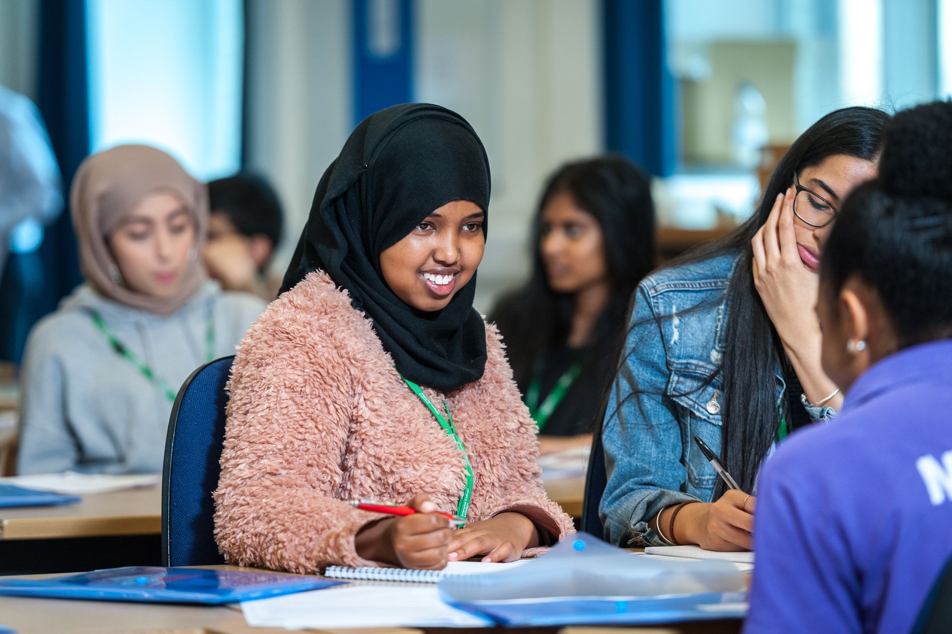 Young woman studying alongside others.